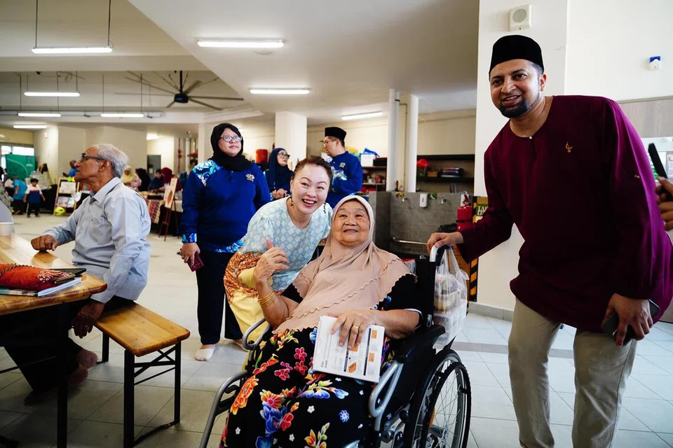 Anggota Parlimen GRC Marine Parade-Braddell Heights, Cik Diana Pang (tiga dari kanan), dan Pengerusi Masjid Khalid, Dr Mohamed Ariffin Mohamed Kawaja Kamaludin (kanan), bergambar bersama seorang penduduk.