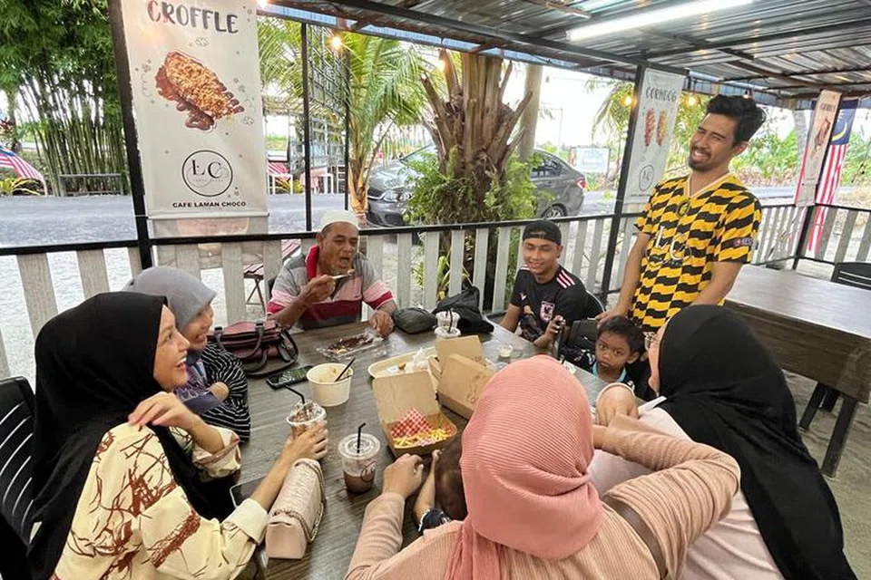 RAI PELANGGAN: Encik Muhammad Farhan Abd Samad (berdiri)  ramah melayan pelanggan di Kafe Laman Choco, di Sungai Besar, Selangor.