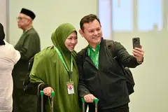Menteri Negara Kanan (Pertahanan merangkap Kemampanan dan Sekitaran), Encik Zaqy Mohamad (kanan) bersama isterinya, Cik Haryane Mustajab di Lapangan Terbang Changi pada 13 Mei sebelum berangkat untuk menunaikan ibadah haji.