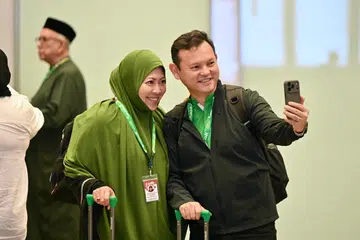 Menteri Negara Kanan (Pertahanan merangkap Kemampanan dan Sekitaran), Encik Zaqy Mohamad (kanan) bersama isterinya, Cik Haryane Mustajab di Lapangan Terbang Changi pada 13 Mei sebelum berangkat untuk menunaikan ibadah haji.