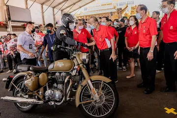 BERMOTOSIKAL DEMI AMAL: Encik Wong (kiri, bertopi keledar), yang turut menunggang motosikal secara berkonvoi, bersalaman dengan Pengerusi Loyang Tua Pek Kong, Encik George Peh, sebaik tiba di acara amal sempena menyambut Hari Kebangsaan dan Hari Keharmonian Kaum anjuran Kumpulan Riders Aid Singapore semalam. - Foto BH oleh NUR DIYANA TAHA