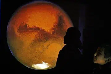 TEROKA ANGKASA LEPAS: UAE akan melancarkan misi meneroka planet Marikh pada Julai ini. Kelihatan seorang budak warga Jordan melihat imej planet Marikh di dinding semasa perhimpunan bagi menyaksikan planet merah itu di langit Amman pada 28 Januari 2010.