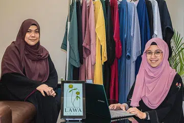 CABARAN BUKAN HAMBATAN: Ustazah Syariati Sulaiman (kanan), yang bersama rakan kongsinya, Cik Nurhani Razali, berkata menceburi bidang perniagaan "memang agak mencabar tetapi secara perlahan kami belajar tentang pemasaran, aspek logistik dan berkomunikasi dengan pembeli" dan meneroka penggunaan media sosial. - Foto BH oleh NUR DIYANA TAHA