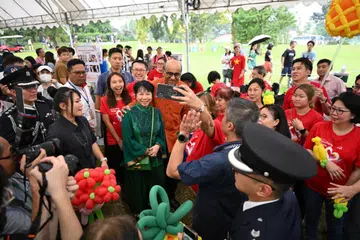 BERMESRA: Presiden Tharman Shanmugaratnam bersama Isterinya, Cik Jane Ittogi Shanmugaratnam (berbaju hijau) bergambar bersama pengunjung semasa rumah terbuka Istana sempena Deepavali pada Ahad.