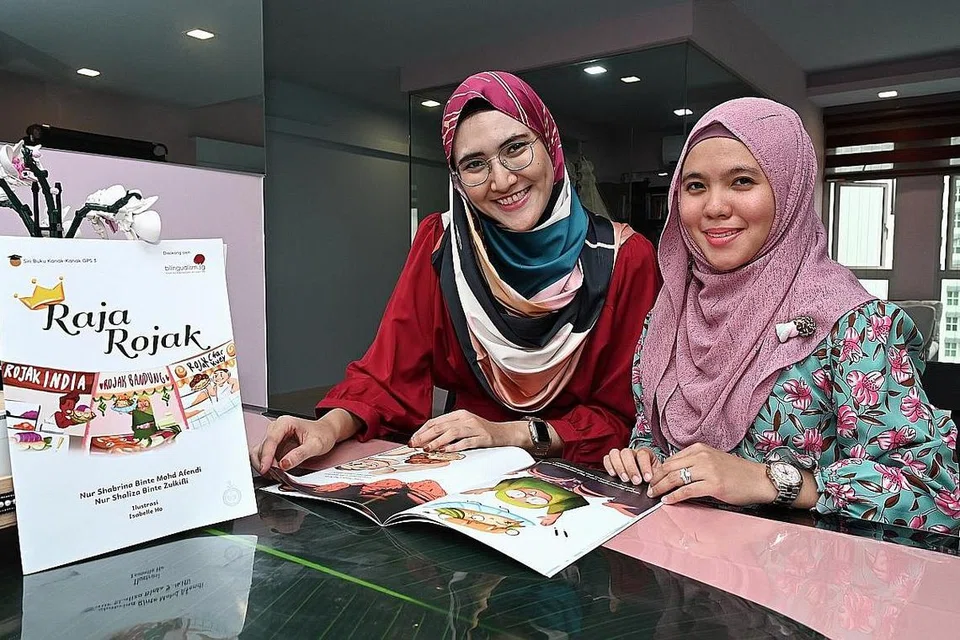 ANALOGI ROJAK KAITKAN WARGA SG: Cikgu Nur Shabrina Afendi (kiri) dan Cikgu Nur Shaliza Zulkifli (kanan) penulis buku 'Raja Rojak', ingin merapatkan jurang kekurangan buku kanak-kanak yang berkonteks Singapura. - Foto BM oleh KHALID BABA 