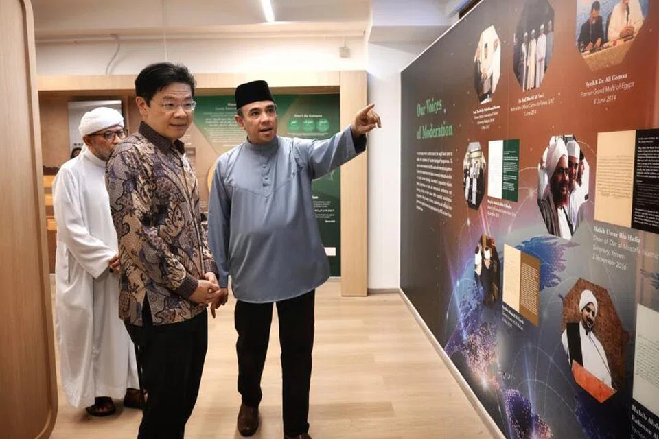 Ustaz Dr Mohamed Ali (kanan) sedang memberikan penerangan kepada Encik Lawrence Wong semasa lawatannya ke Galeri Majulah di Masjid Khadijah pada 1 April. Pengerusi Bersama Kumpulan Pemulihan Keagamaan (RRG), Ustaz Mohamad Hasbi Hassan (kiri).