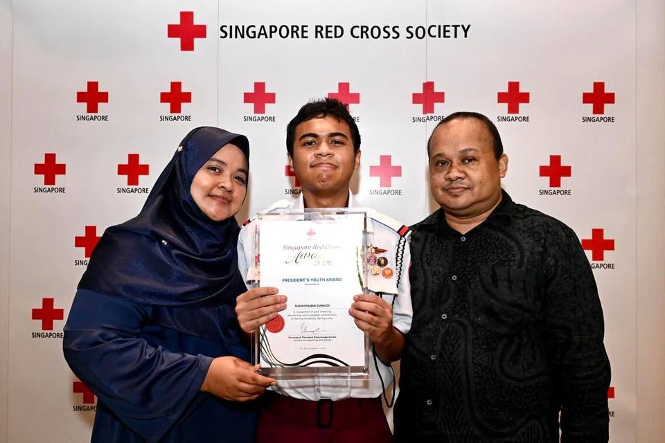 Suhaifiq Suhaidi, 16, penerima Anugerah Belia Presiden pada majlis Anugerah Palang Merah Singapura. Beliau bergambar bersama ibu bapanya.