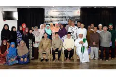 MENYERIKAN ACARA: Profesor Madya Muhammad Faishal Ibrahim (duduk di kerusi, dua dari kiri) bergambar bersama penduduk Yishun dan Kebun Baru yang bakal menunaikan ibadah haji di Masjid Darul Makmur semalam. - Foto JOHARI RAHMAT