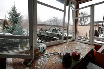 TERUS DIBEDIL: Sebuah kereta kebal yang musnah dilihat melalui tingkap rumah yang turut musnah di bandar Bucha dekat ibu kota Ukraine, Kyiv, yang menjadi sasaran serangan tentera Russia sedang peperangan kededua negara itu memasuki hari ketujuh semalam. - Foto REUTERS