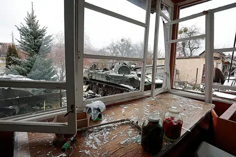 TERUS DIBEDIL: Sebuah kereta kebal yang musnah dilihat melalui tingkap rumah yang turut musnah di bandar Bucha dekat ibu kota Ukraine, Kyiv, yang menjadi sasaran serangan tentera Russia sedang peperangan kededua negara itu memasuki hari ketujuh semalam. - Foto REUTERS