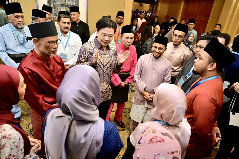 Perdana Menteri Encik Lawrence Wong (tengah, baju batik), ketika masih Timbalan Perdana Menteri, beramah mesra dengan para tetamu di Majlis Perjumpaan Hari Raya Menteri 2024 pada 19 April, diiringi Menteri Bertanggungjawab bagi Ehwal Masyarakat Islam, Encik Masagos Zulkifli Masagos Mohamad (kiri, baju merah), Presiden Majlis Ugama Islam Singapura (Muis), Encik Saat A. Rahman (di kiri Encik Wong), dan Mufti Dr Nazirudin Mohd Nasir (di kiri Encik Saat).
