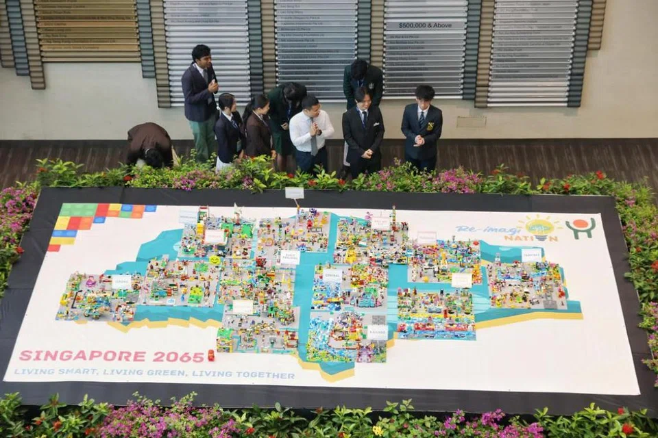 Menteri Pendidikan, Encik Desmond Lee (empat dari kanan), melihat model Singapura pada 2065 yang dibina oleh pelajar semasa majlis penutup, Seminar Prauniversiti 2025, pada 5 Jun.