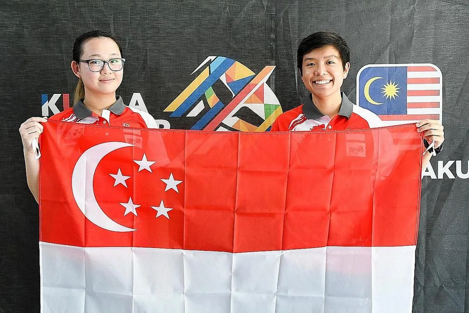 DUA, TIGA SINGAPURA: Teh Xiu Hong (kiri) dan Nicole Tan meraih pingat perak dan gangsa melalui acara pistol 25 meter individu wanita semalam. - Foto SPORTSG