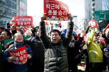 GEMBIRA: Sekumpulan warga Korea Selatan begitu gembira selepas mendengar keputusan mahkamah tertinggi negara itu yang mengekalkan undi tidak percaya terhadap Cik Park Geun-hye di Parlimen. - Foto: REUTERS, AFP