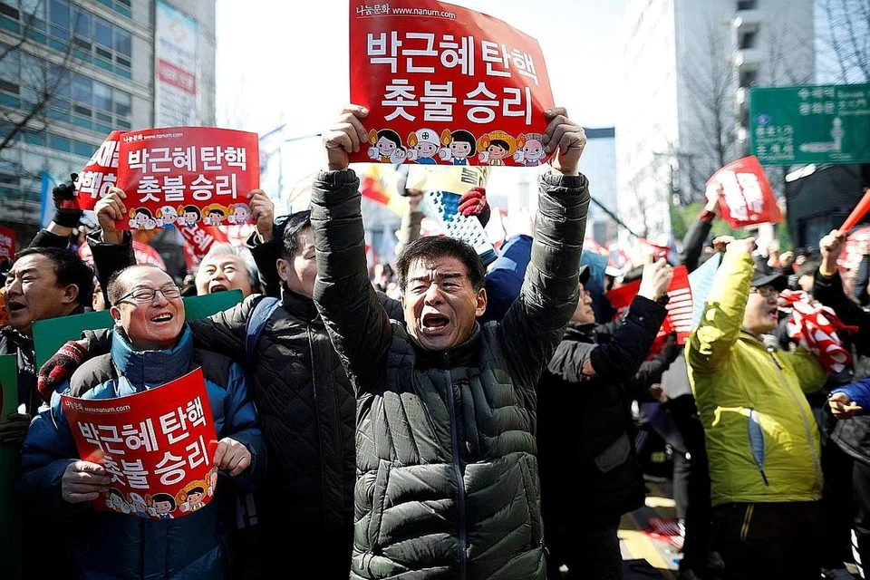 GEMBIRA: Sekumpulan warga Korea Selatan begitu gembira selepas mendengar keputusan mahkamah tertinggi negara itu yang mengekalkan undi tidak percaya terhadap Cik Park Geun-hye di Parlimen. - Foto: REUTERS, AFP