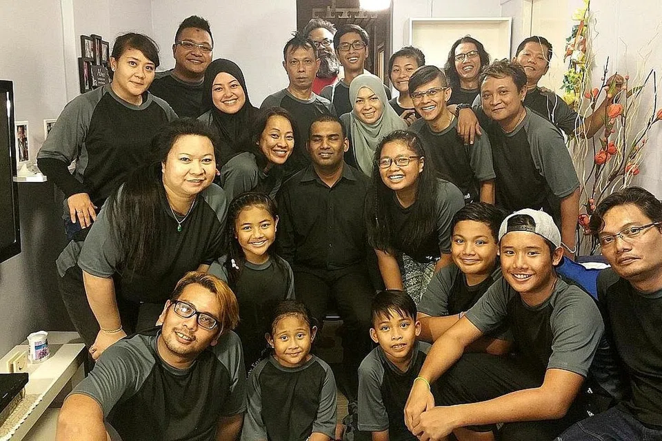 GEMBLENG TENAGA: Encik Hazizi (barisan belakang, kiri) bersama relawan BYSD lain yang terlibat dalam rancangan di saluran Mediacorp Suria berjudul 'Raya Istimewa', yang mengubah elok kediaman keluarga warga kurang upaya sempena Hari Raya pada 2015. - Foto PERSATUAN BELIA BEDOK UNTUK INSAN KURANG UPAYA