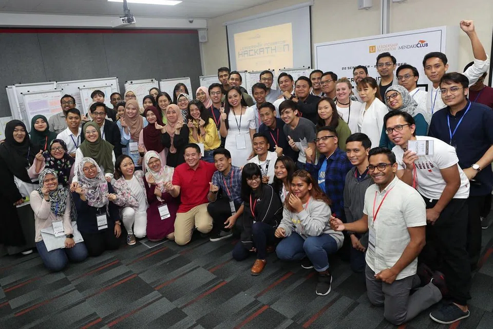 PROGRAM BANGUN KEPIMPINAN BELIA: Setiausaha Parlimen Kanan (Ehwal Dalam Negeri merangkap Kesihatan), Encik Amrin Amin (duduk, berbaju merah) bersama peserta hackathon di bawah program Inkubator Kepimpinan (LI) Kelab Mendaki baru-baru ini. - Foto BH oleh TIMOTHY DAVID