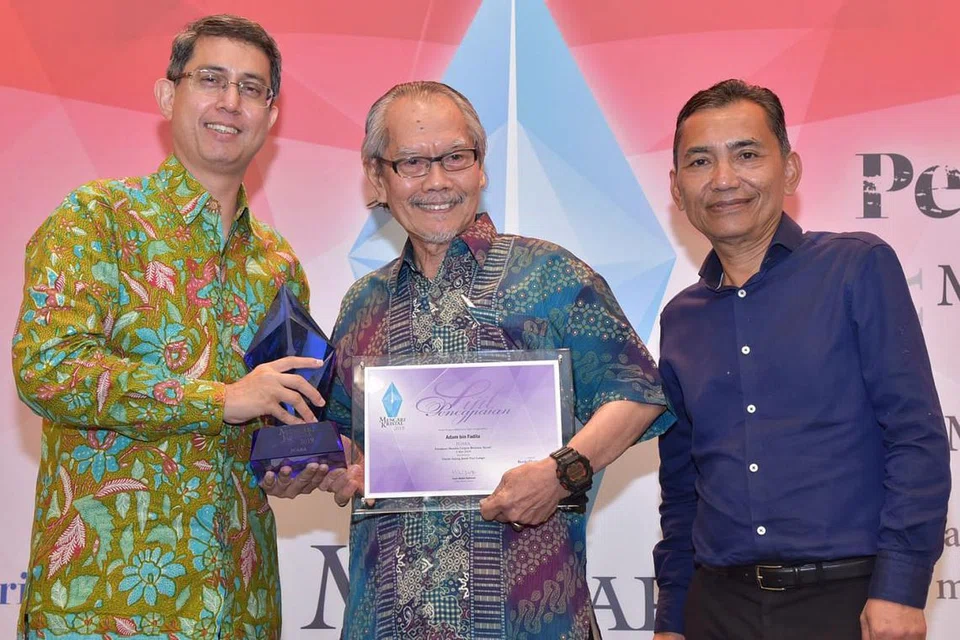 MERAIKAN KEMENANGAN: Encik Adam Fadila menerima hadiah daripada tetamu terhormat, Setiausaha Parlimen Kanan (Pendidikan merangkap Pembangunan Sosial dan Keluarga), Profesor Madya Muhammad Faishal Ibrahim, dan Editor Berita Harian, Encik Saat Abdul Rahman (kanan). - Foto CHAIRUL FAHMY HUSSAINI