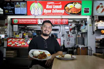 NIAGA BERSAMA: Bersama isteri dan seorang rakan baiknya, Encik Noorman Mubarak, memulakan gerai Nasi Lemak Ayam Taliwang pertamanya di Pusat Penjaja Yishun Park pada 2017.