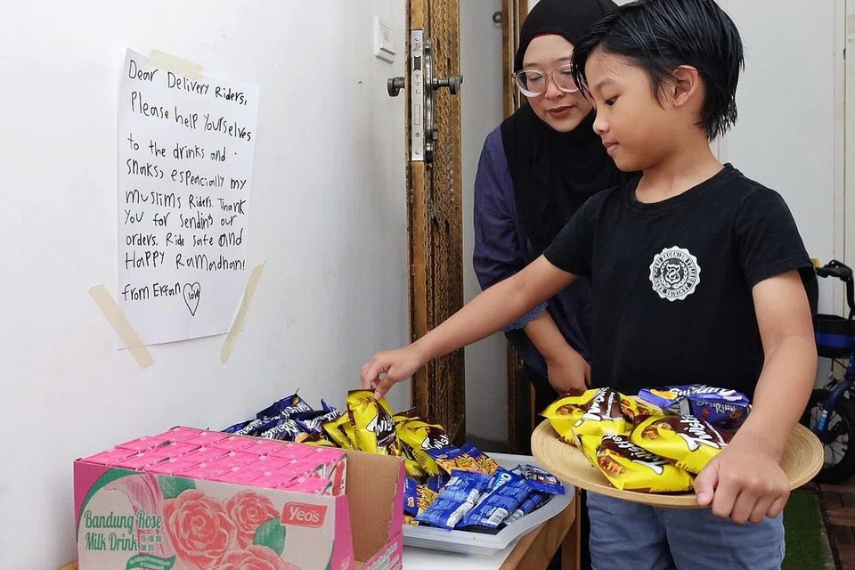 TAMBAH STOK: Cik Erma dan anak lelaki sulungnya, Erfan, menyediakan minuman kotak serta makanan ringan khas bagi penghantar makanan sempena bulan Ramadan ini. - Foto BH oleh KHALID BABA