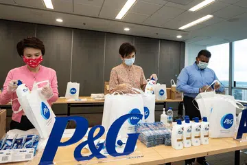 PEK IHSAN: (Dari kiri) Cik Low Yen Ling, Cik Josephine Teo dan Encik Yeo Guat Kwang menyertai sukarelawan P&G dalam satu acara pembungkusan pek pada 25 April 2020 untuk diagihkan kepada pekerja asing di Singapura. 