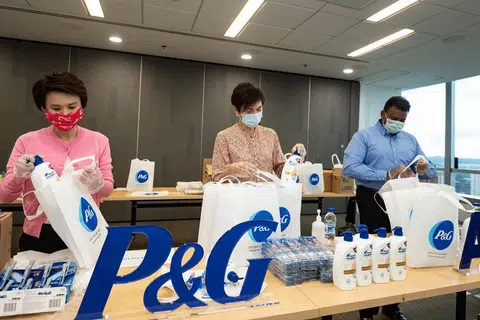 PEK IHSAN: (Dari kiri) Cik Low Yen Ling, Cik Josephine Teo dan Encik Yeo Guat Kwang menyertai sukarelawan P&G dalam satu acara pembungkusan pek pada 25 April 2020 untuk diagihkan kepada pekerja asing di Singapura. 