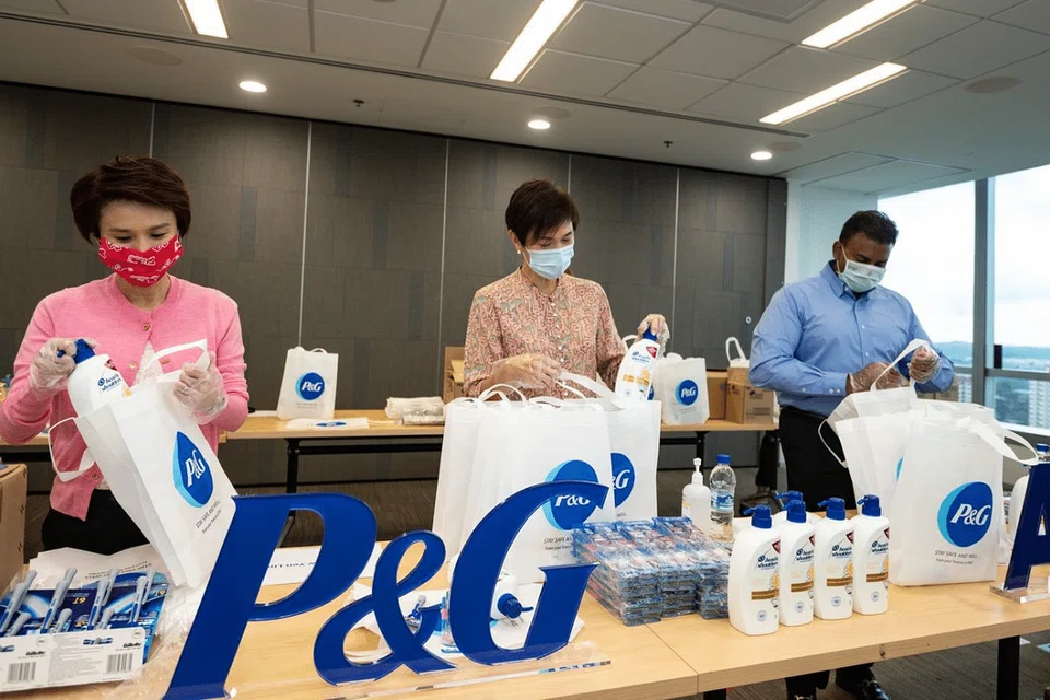 PEK IHSAN: (Dari kiri) Cik Low Yen Ling, Cik Josephine Teo dan Encik Yeo Guat Kwang menyertai sukarelawan P&G dalam satu acara pembungkusan pek pada 25 April 2020 untuk diagihkan kepada pekerja asing di Singapura. 