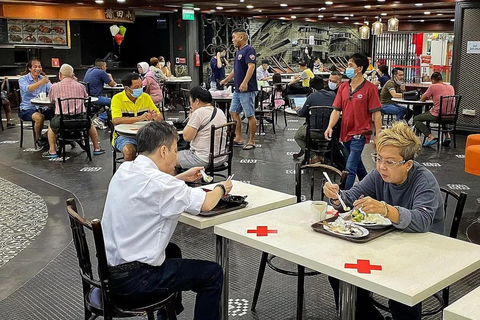 MASIH RAMAI PELANGGAN: Orang ramai dilihat sedang menjamu selera secara berseorang atau berpasangan di sebuah pusat makanan yang terletak Tiong Bahru Plaza semalam. - Foto BH oleh CHONG JUN LIANG