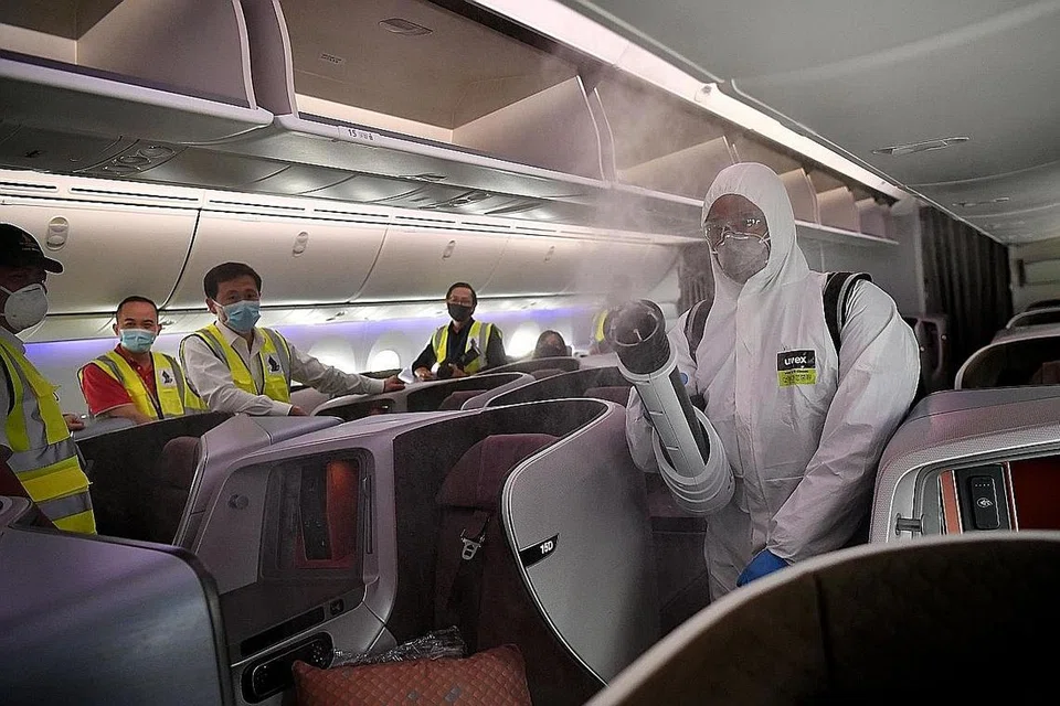 PERALATAN BARU: Encik Ong (tiga dari kiri) menyaksikan seorang pekerja menggunakan alat penyembur elektro-statik bagi penyahjangkitan pesawat. Alat baru itu akan diperkenalkan sebagai sebahagian fasa kedua program transformasi syarikat SIA Engineering. - Foto BH oleh LIM YAOHUI