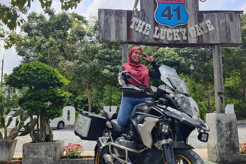SERONOK TUNGGANG MOTOSIKAL: Cik Radiah Sumadi bergambar di depan kedai makan halal Route41 Phatthalung di Phatthalung, Thailand. Kedai makan ini, yang terkenal dalam kalangan penunggang motosikal, terletak sekitar separuh jalan antara Hat Yai dengan Krabi.
