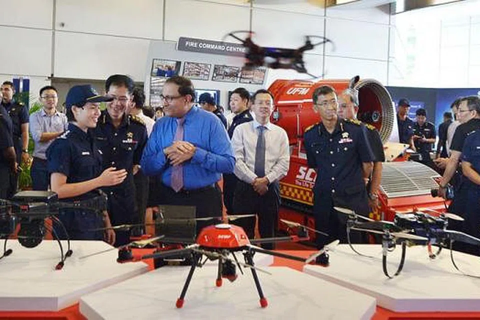 TEKNOLOGI SCDF BARU: Encik S Iswaran ditunjukkan alat dron yang berupaya memberi pemandangan luas bagi kawasan operasi. - Foto THE STRAITS TIMES