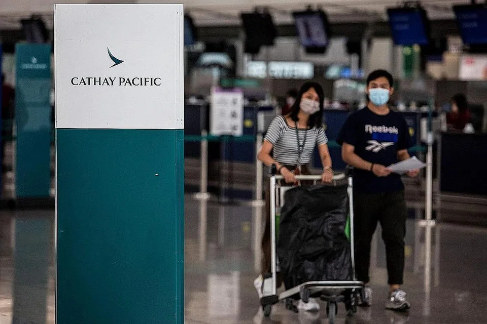 KES RENDAH: Penumpang berjalan lewat kaunter daftar masuk syarikat penerbangan Cathay Pacific di Lapangan Terbang Antarabangsa Hong Kong bulan lalu. Hong Kong menyaksikan kurang 10 kes Covid-19 hampir setiap hari sejak akhir bulan lalu. - Foto AFP