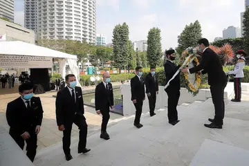 SUSUR MEMORI PEDIH: Wakil Dewan Perniagaan dan Perusahaan Cina Singapura (SCCCI) menyumbang lingkaran bunga dalam Upacara Memperingati Peperangan yang ke-54 di Taman Peringatan Perang, Beach Road, semalam. - Foto BH oleh GAVIN FOO