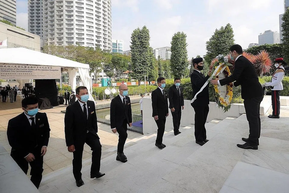 SUSUR MEMORI PEDIH: Wakil Dewan Perniagaan dan Perusahaan Cina Singapura (SCCCI) menyumbang lingkaran bunga dalam Upacara Memperingati Peperangan yang ke-54 di Taman Peringatan Perang, Beach Road, semalam. - Foto BH oleh GAVIN FOO