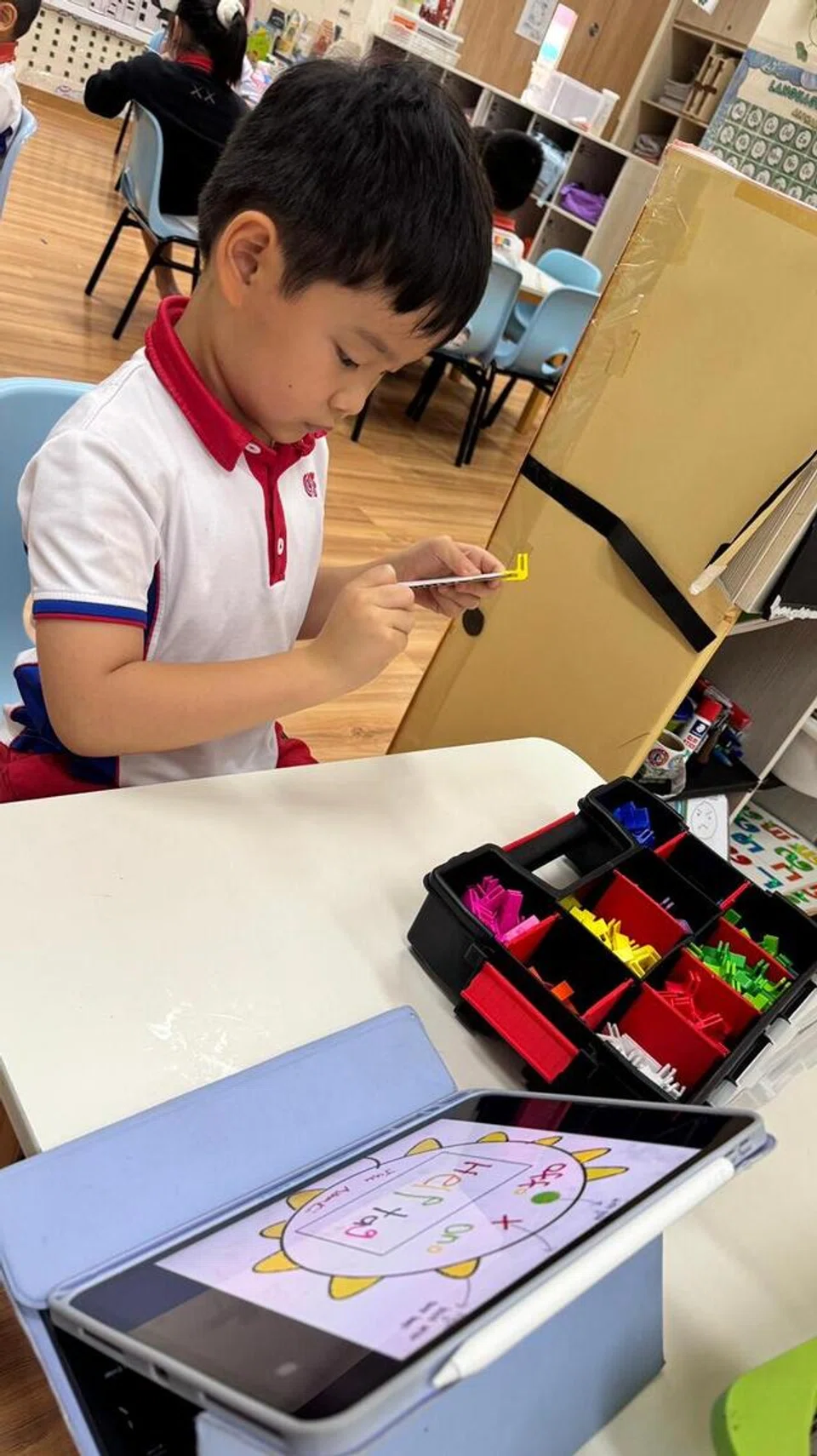 Jude Huang Jun Rong memasang beberapa komponen untuk menghasilkan prototaip ‘HelpTag’.