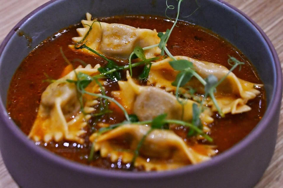 Hidangan Braised Beef Agnolotti del Plin menampilkan pasta buatan tangan berinti daging lembu yang dimasak perlahan, disajikan bersama jus daging, keju parmesan, herba segar dan mentega cair.