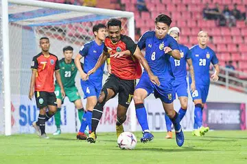 TERLALU GAGAH: Pasukan Thailand (berjersi biru) terbukti terlalu sukar bagi pasukan Timor-Leste (berjersi merah) dan kecekapan pemain Thailand telah menghasilkan tujuh gol dalam perlawanan pertama kededua pasukan ini. - Foto FACEBOOK PIALA AFF SUZUKI