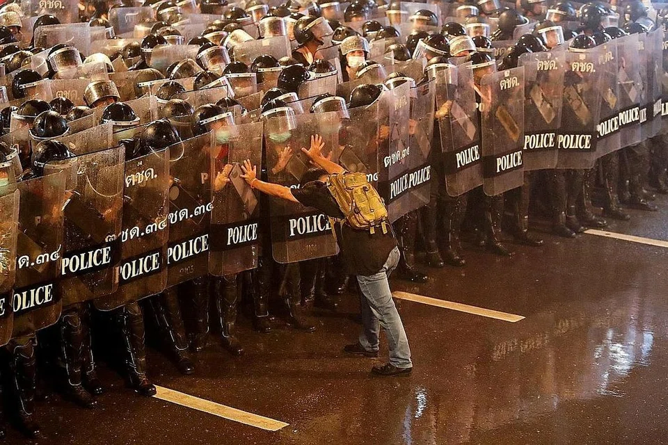 ADAKAN BANTAHAN: Anurak Jeantawanich, 52 tahun, cuba menolak beberapa anggota polis sewaktu bantahan anti kerajaan di Bangkok, Thailand. - Foto REUTERS