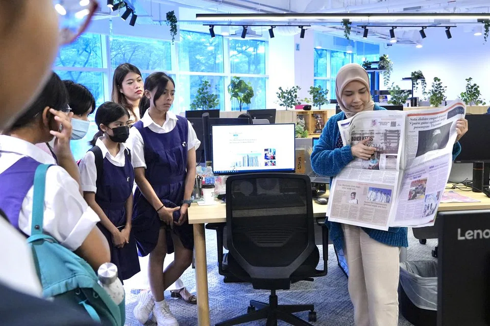Penyunting BH, Cik Nurfahruriza Ismail (kanan) berkongsi dengan pelajar Sekolah Perempuan Raffles bagaimana penyunting menyusun atur kandungan di halaman akhbar Berita Harian.