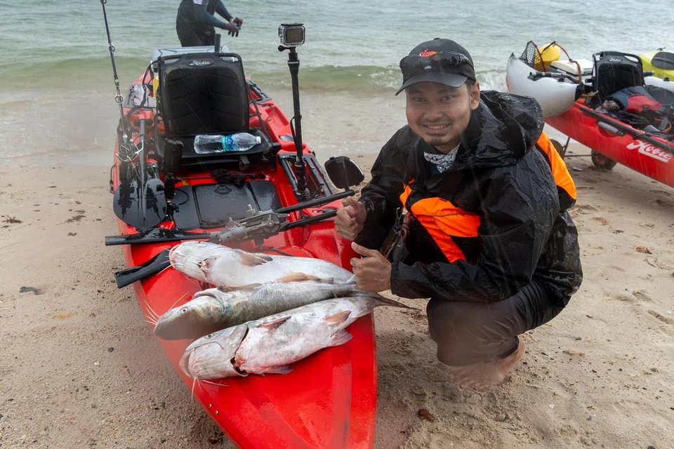 Wartawan BM, Muhd Hazman Abd Aziz, bergambar bersama tiga ikan duri jahan yang ditangkapnya. 