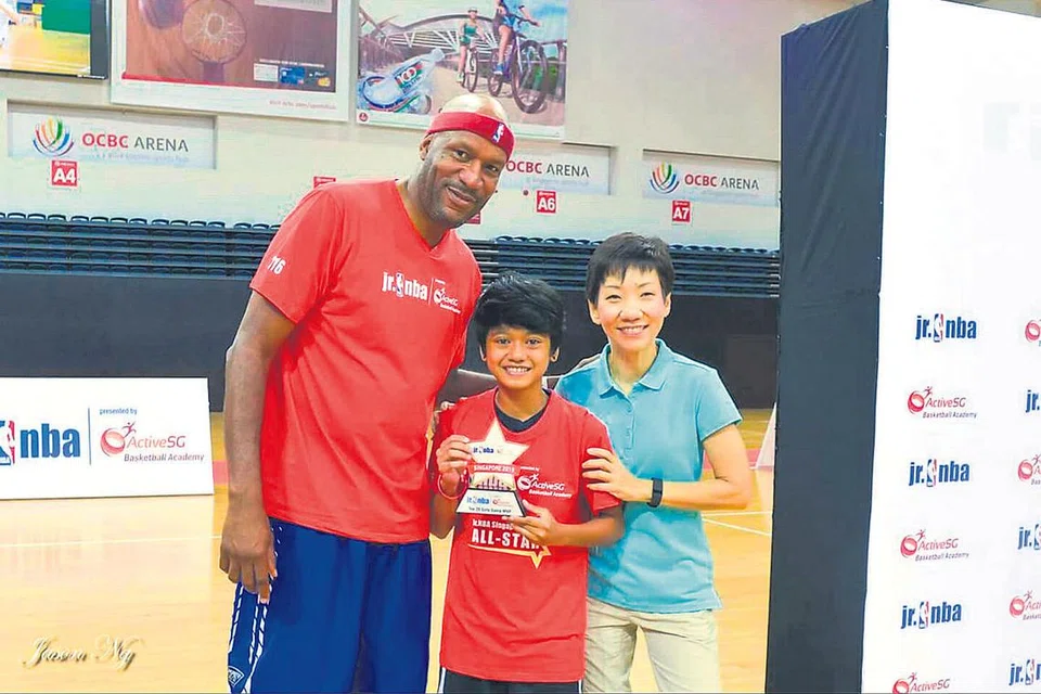 BERPELUANG JUMPA BINTANG: Fatin (tengah) seronok berpeluang bertemu dan bergambar dengan bintang bola keranjang Amerika, Ron Harper. Menteri Kebudayaan, Masyarakat dan Belia, Cik Grace Fu, turut mengunjungi kem latihan tersebut. - Foto MY ACTIVE SG 