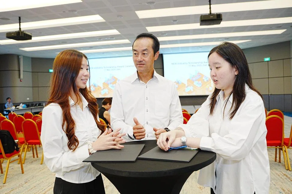 Menteri Negara Kanan Kemampanan dan Sekitaran, Dr Koh Poh Koon (tengah) bersembang dengan dua pemegang biasiswa NEA-Industri, Cik Kellyn Ng (kiri) dan Cik Cecellia Chan (kanan) semasa majlis penyampaian anugerah  di Bangunan Sekitaran pada 17 Mei. 