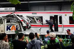 Orang ramai menyaksikan juruteknik menjalankan kerja di lokasi kejadian selepas perlanggaran maut antara tren komuter dan tren jarak jauh di Bekasi, pinggir Jakarta, Indonesia, 28 April 2026.   