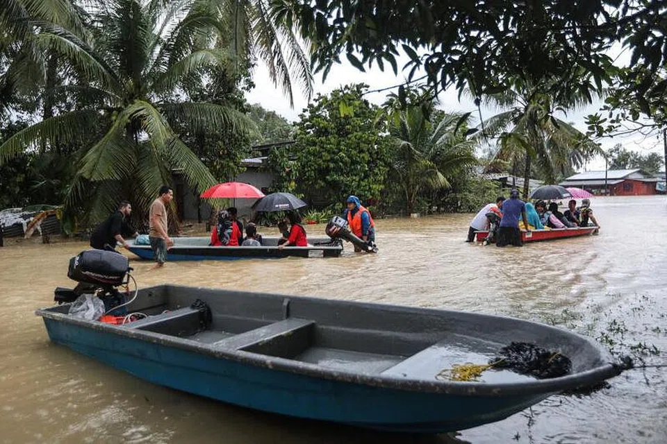 Orang ramai menggunakan bot untuk melalui kawasan banjir di Kuala Terengganu, Malaysia. Di Terengganu, pihak berkuasa menyatakan jumlah penduduk yang berlindung di 112 pusat pemindahan sementara (PPS) menurun kepada 15,243 mangsa berbanding 20,552 mangsa pada Jumaat malam, 