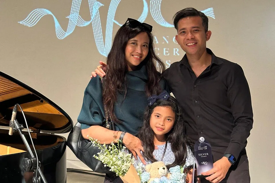 Eliza Sophia Mohammad Matin (tengah) bersama ibu bapanya, Cik Este’ehara Rosli (kiri) dan Mohammad Matin Mohdari semasa mereka di ‘APCS Classical Festival’ di Jakarta pada 2024. Eliza berjaya merangkul anugerah perak di festival itu.