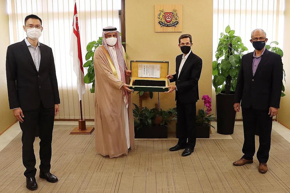 HADIAH DARI SAUDI: Encik Alami (dua dari kanan) menerima kiswah daripada Encik Al Saleh, dalam majlis yang turut dihadiri oleh Encik Masagos (kanan) dan Encik Esa. Ia bagi mengiktiraf khidmat Muis kepada masyarakat Muslim di sini. - Foto MSF