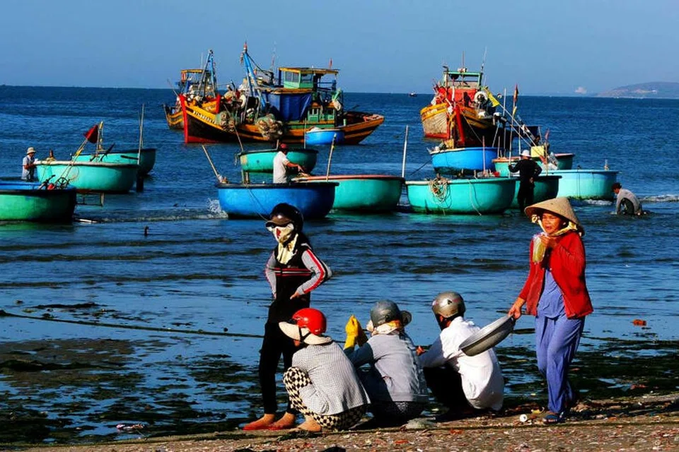 PENANTIAN MENGGEMBIRAKAN: Pekerja kampung nelayan berada di tepi lautan untuk menanti ketibaan nelayan yang datang dengan muatan bot sarat ikan hasil tangkapan.