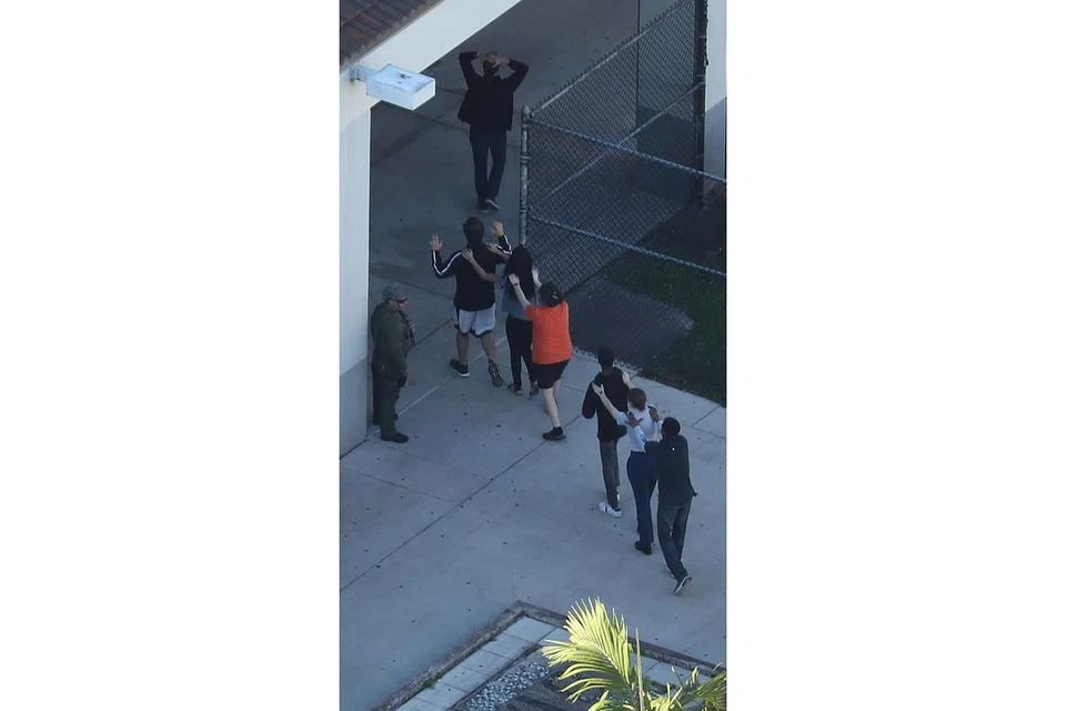 DISELAMATKAN: Sekumpulan orang dibawa keluar dari Sekolah Tinggi Marjory Stoneman Douglas selepas berlaku serangan tembakan rambang yang mengakibatkan ramai terbunuh dan cedera. - Foto AFP 