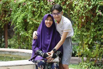 SUMBER DORONGAN: Pelajar Sekolah Rendaah Palm View, Muhammad Raiyan bersama neneknya, Cik Katirah, selepas mendapat tahu keputusan PSLE. Cik Katirah telah menjadi pengasuh utama Muhammad Raiyan setelah kematian ibunya apabila dia hanya berusia empat tahun. - Foto BH oleh MARCELLIN LOPEZ