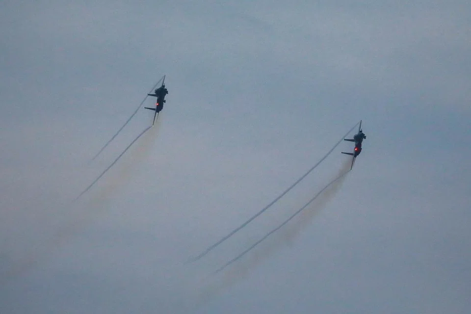 PERTUNJUKAN AEROBATIK: Dua jet pejuang F-15SG melakukan pergerakan aerobatik.